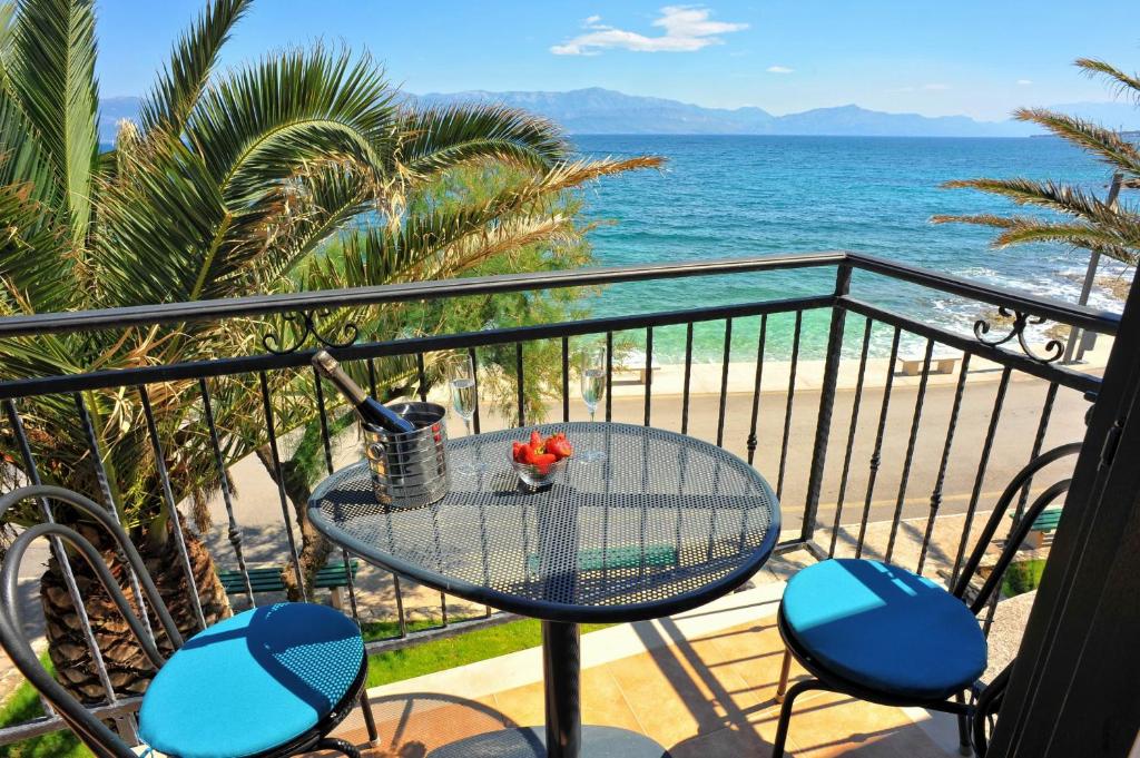 einen Tisch und Stühle auf einem Balkon mit Strandblick in der Unterkunft Holiday Home Lučica in Sutivan