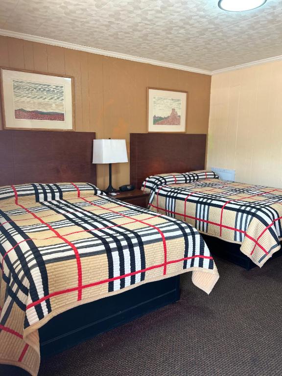 a hotel room with two beds with striped sheets at Deavers motel in Grove Hill