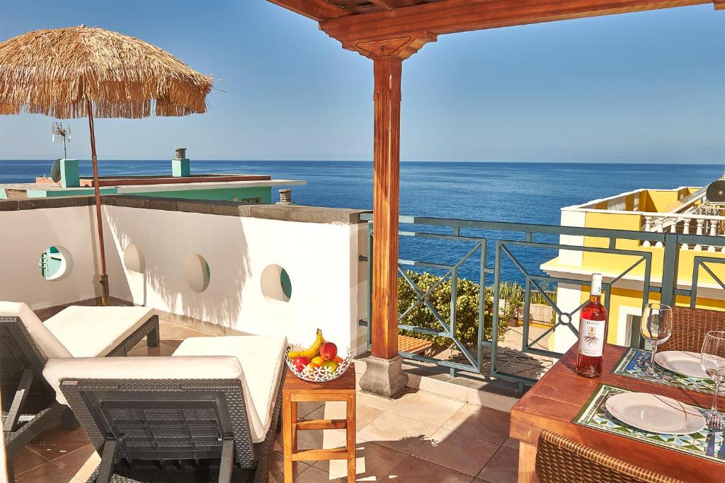 a balcony with a table and chairs and the ocean at Duplex Canela in Puerto Naos