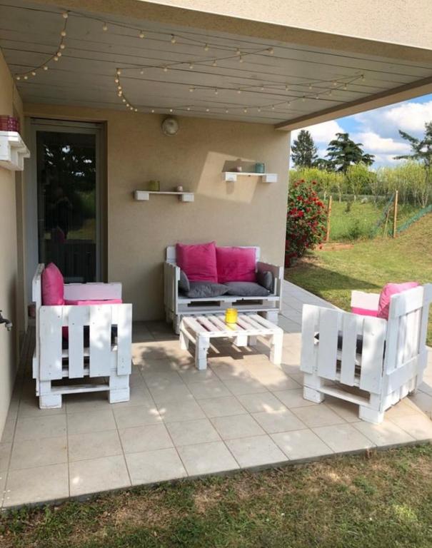 d'une terrasse avec 2 chaises blanches et un canapé. dans l'établissement Le cocon de Stef, à Salies-de-Béarn