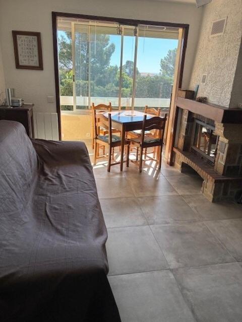 un salon avec une table et une cheminée dans l'établissement appartement bord de mer, Esterel, à Agay