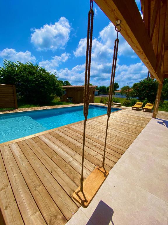 une piscine avec une terrasse en bois à côté d'une piscine dans l'établissement Belle Villa Terra Mare entre océan et bassin, à Lège-Cap-Ferret
