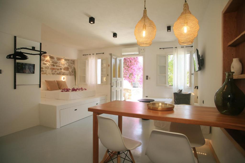 una cucina con tavolo in legno e sedie bianche di Axilleion Boutique Hotel a Ermoupoli