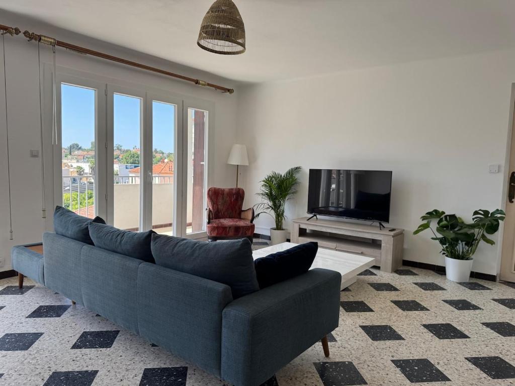 un salon avec un canapé bleu et une télévision dans l'établissement 75 m2 2-bedroom apartment in Toulon, à Toulon