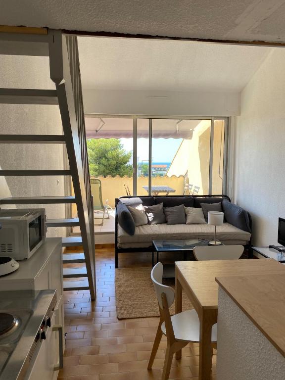 un salon avec un canapé et une table dans l'établissement studio à 400m de la plage de la Corniche, à Sète
