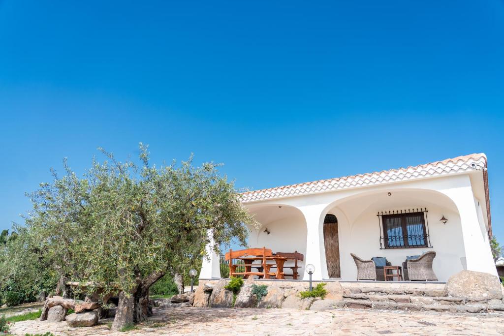 a small white house with a table and chairs at Villa Aratza in Orosei