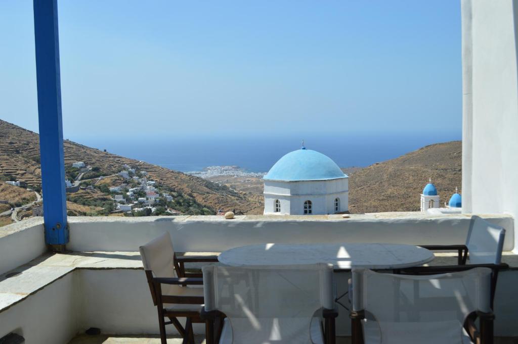a table and chairs on a balcony with a building at Karyatides Houses in Kariá