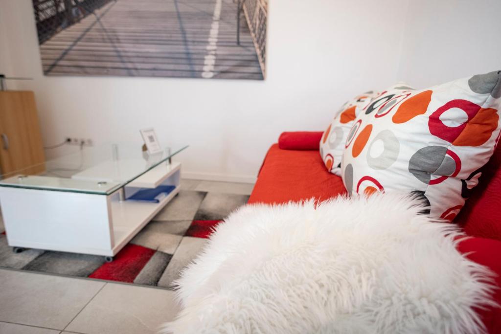 a living room with a red couch and a white rug at AbraCadabra Flat France Suisse in Saint-Louis