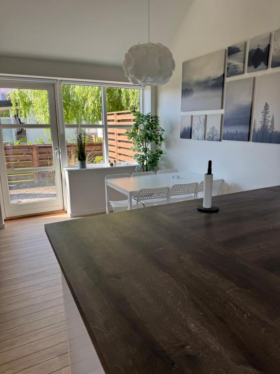 a living room with a table and benches and windows at Bøtø strand ferielejlighed 2 in Bøtø By