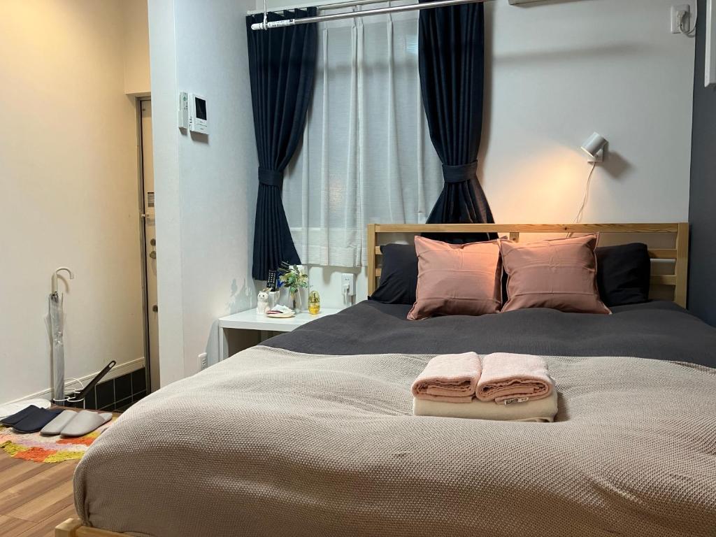 a bedroom with a large bed with two towels on it at 102 山手线近上野一站温馨新公寓 in Tokyo