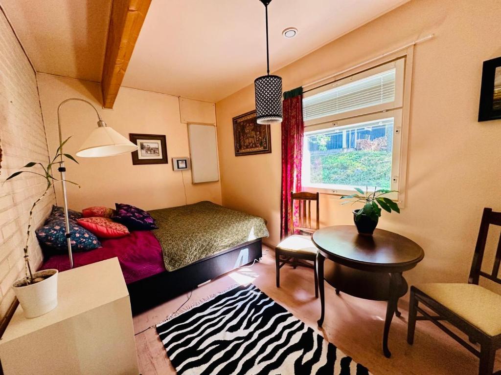 a bedroom with a bed and a table and a window at Blueberry Villa at Saimaa Lakeside in Taipalsaari