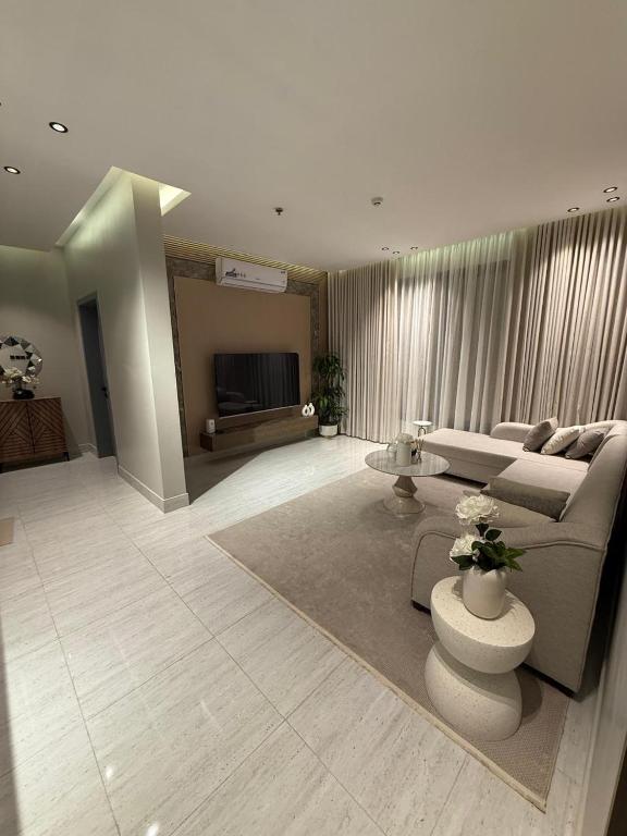 a living room with a couch and a tv at Apartment near Alraka Corniche شقة بجانب كورنيش الراكة in Dammam