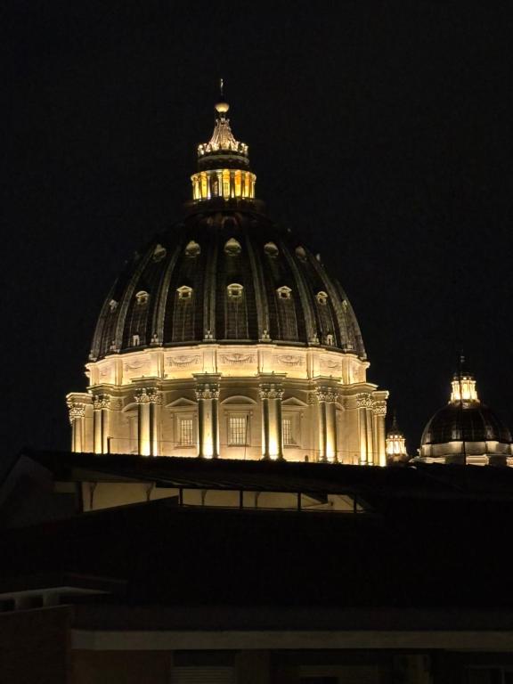 a domed building with lights at night at Saint Peter's Sunset View Luxury Apartment in Rome