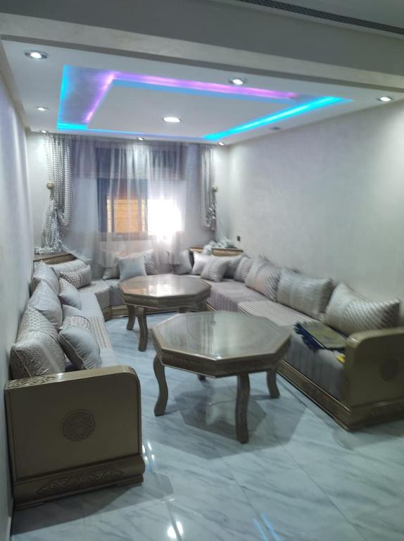 a living room with couches and tables in a room at Al HOCEIMA in Tirhanimîne