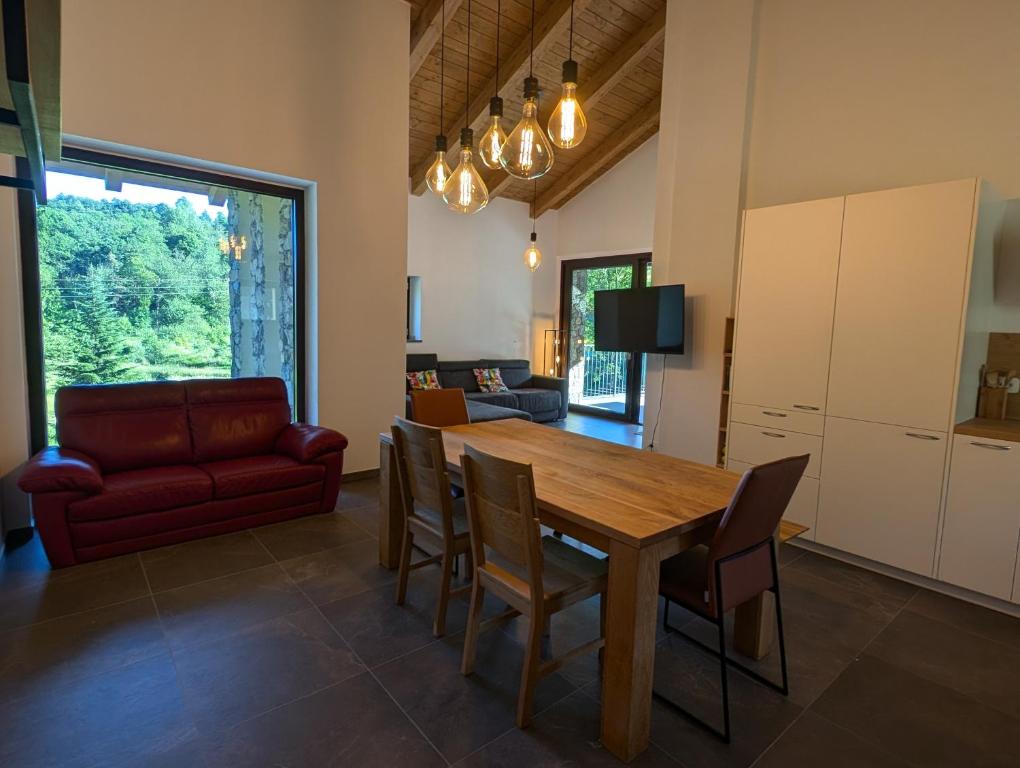 a living room with a wooden table and a red couch at Villa nel Bosco in Cairo Montenotte