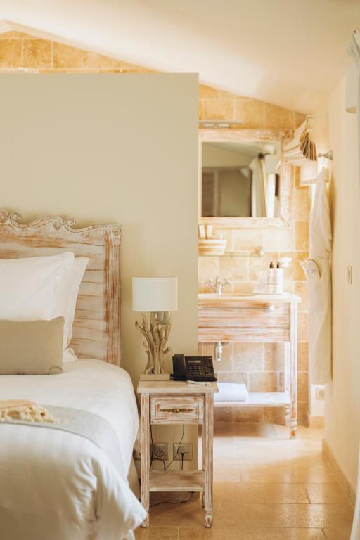 a bedroom with a bed and a bathroom with a sink at La Bastide des Salins in Saint-Tropez