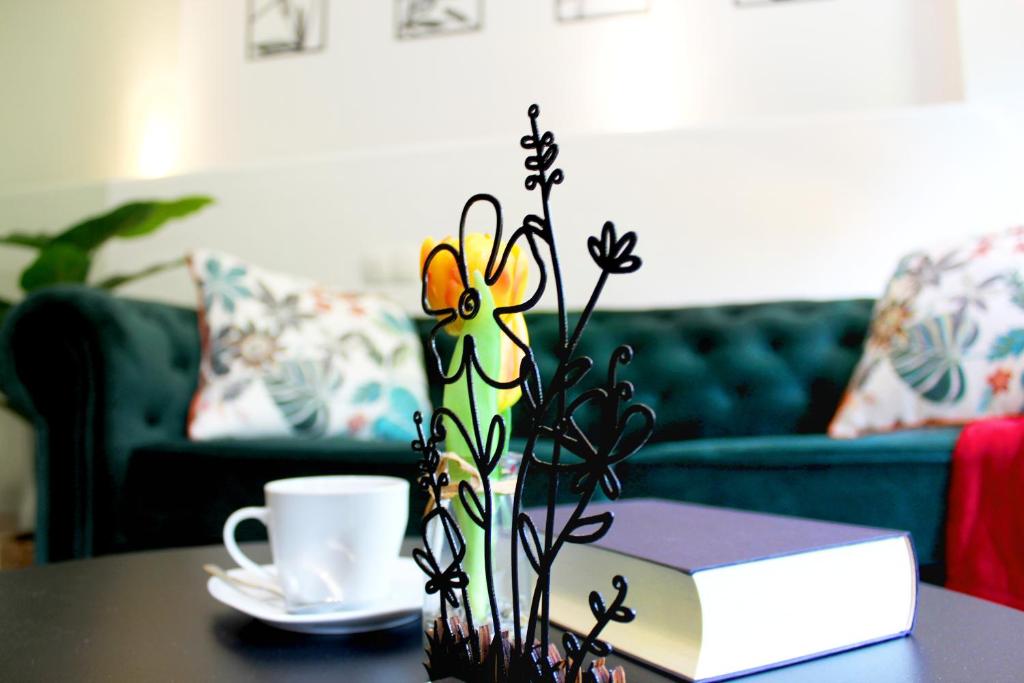 un libro e un vaso di fiori su un tavolo con una tazza di caffè di Rost Apartments - Laufen a Laufen