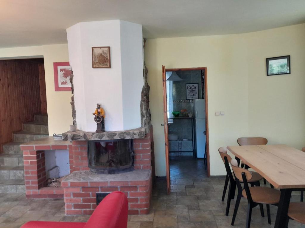 a living room with a brick fireplace and a table at Apartament nad jeziorem in Małe Swornegacie