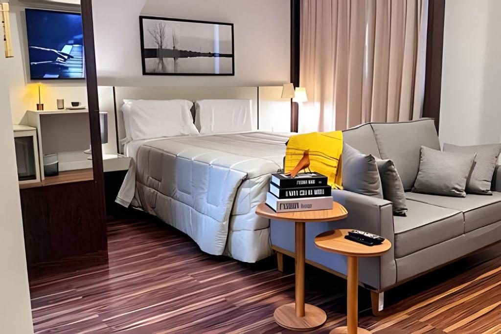 ein Hotelzimmer mit einem Bett und einer Couch in der Unterkunft Flat prox. MASP e Av. Paulista - Limpeza Diária in São Paulo