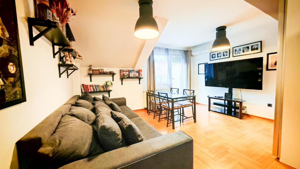 uma sala de estar com um sofá e uma TV de tela plana em FilinHome Dusana Suite 2 em Novi Sad