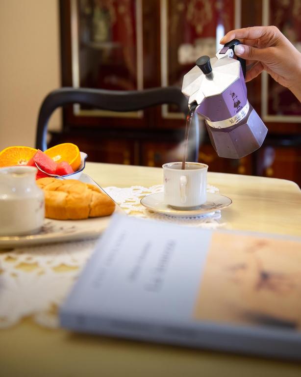 a person is pouring coffee into a cup on a table at La perla sul Tirreno in Briatico