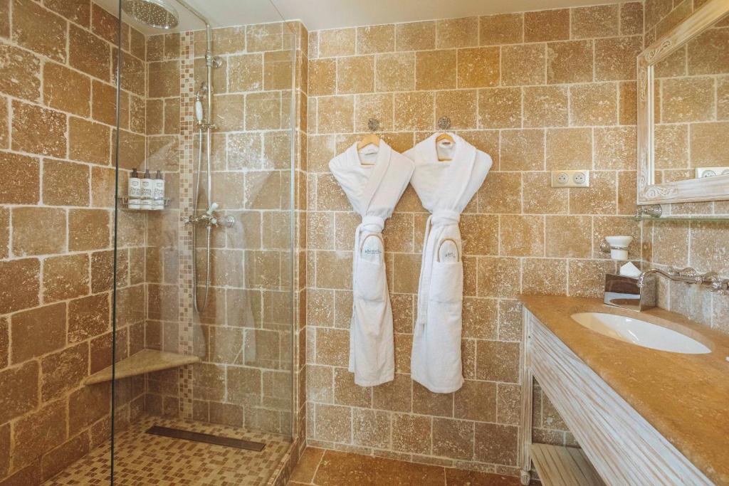 a bathroom with a shower and a sink and towels at La Bastide des Salins in Saint-Tropez
