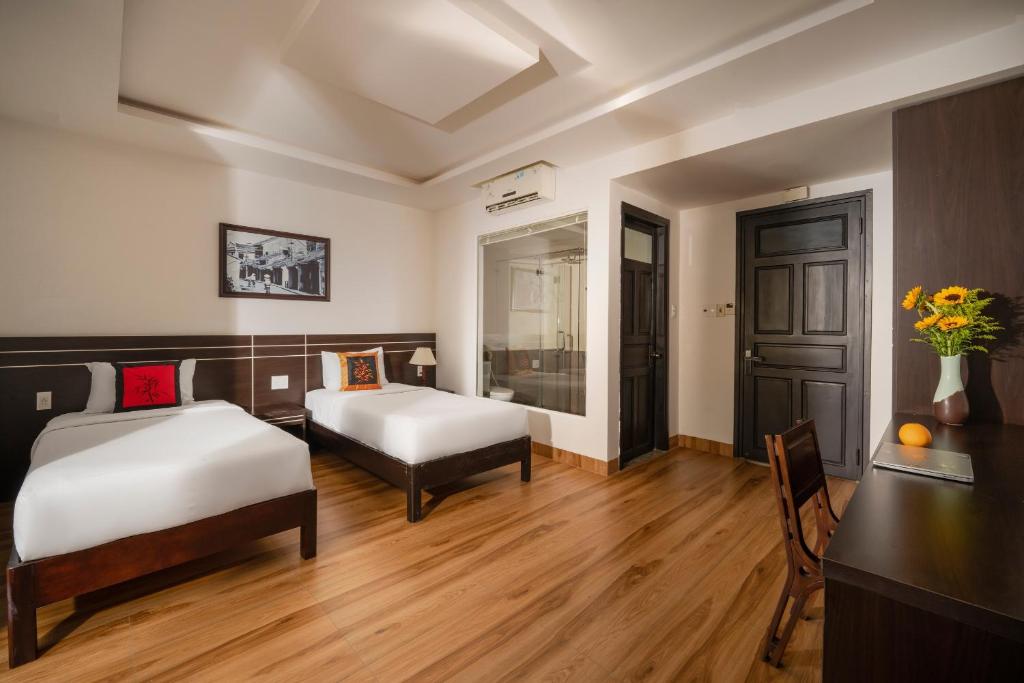 Postel nebo postele na pokoji v ubytování Hoi An Beach Hotel