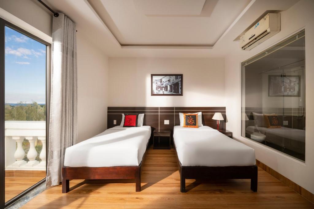 Postel nebo postele na pokoji v ubytování Hoi An Beach Hotel