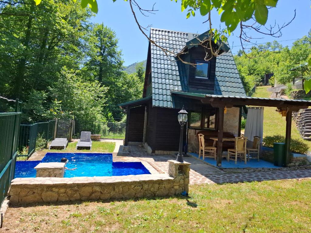 a backyard with a pool and a house at Koliba TAMAN in Konjic