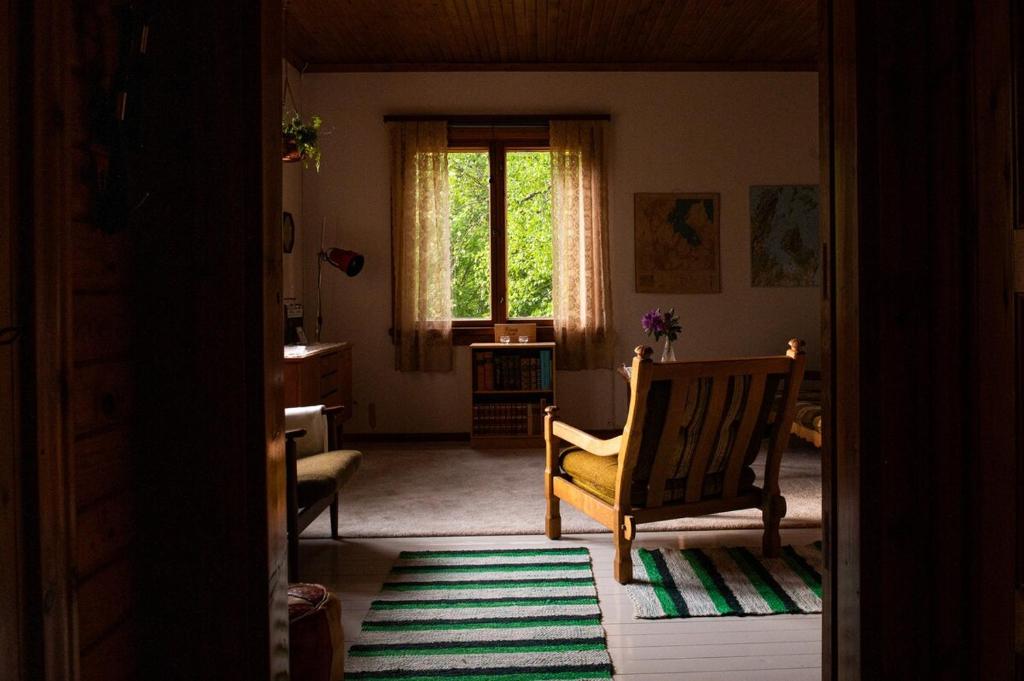 a living room with a chair and a window at Scandinavian summer cottage in Asikkala in Asikkala