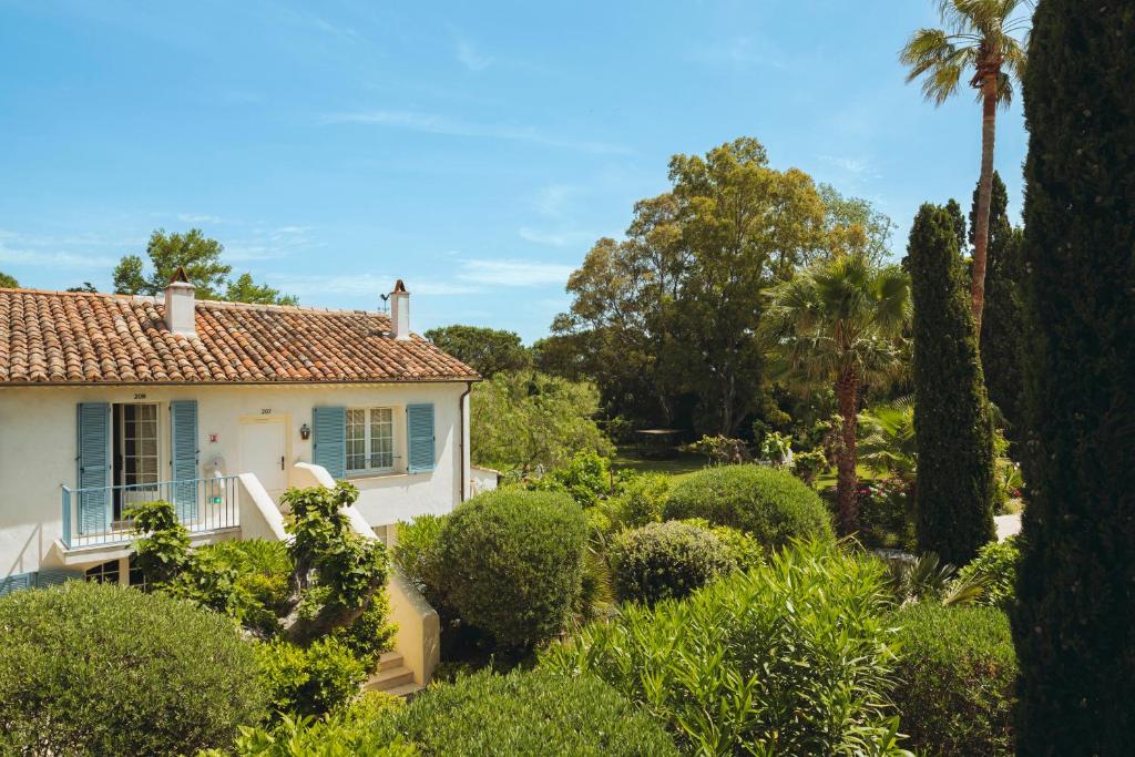 a white house with trees and bushes at La Bastide des Salins in Saint-Tropez