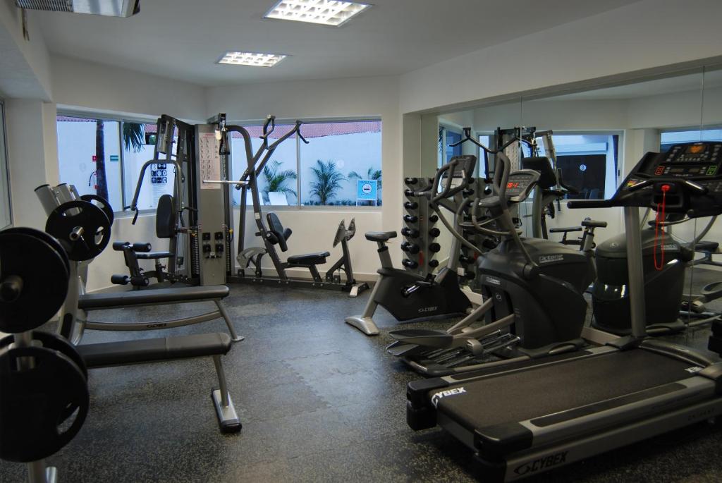 a gym with several treadmills and exercise bikes at Adhara Express in Cancún