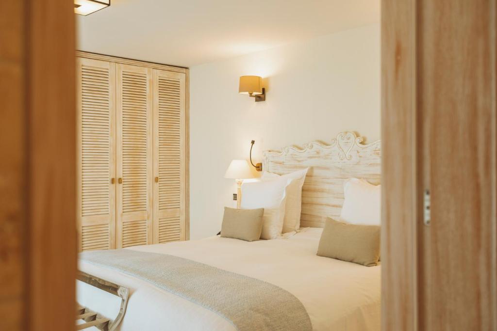 a bedroom with a large white bed with white pillows at La Bastide des Salins in Saint-Tropez