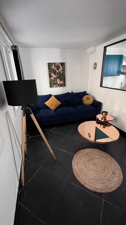 un salon avec un canapé bleu et une table dans l'établissement Charmante maison de ville, à Saint-Laurent-du-Var