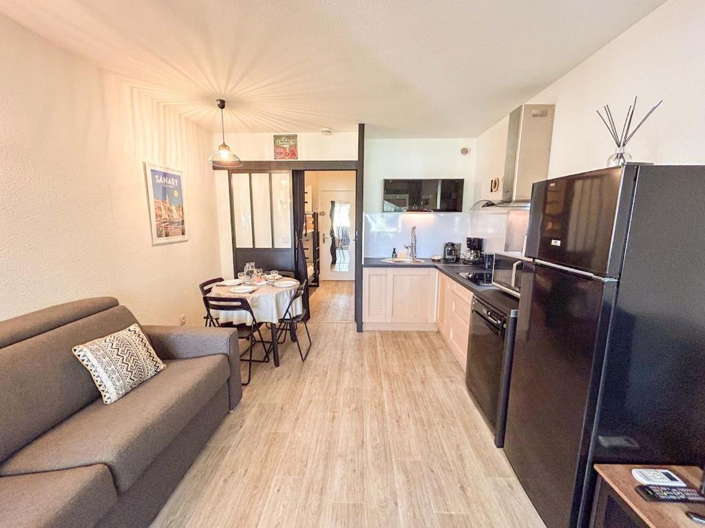 un salon avec un canapé et une cuisine dans l'établissement Studio dans une résidence avec piscine à Sanary, à Sanary-sur-Mer