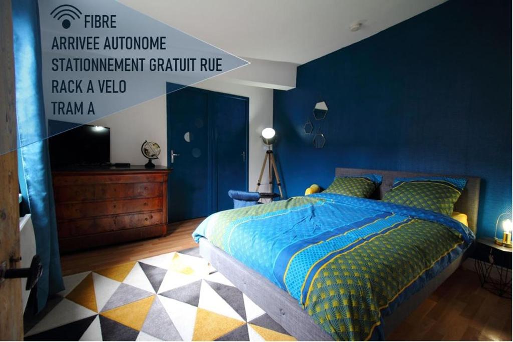 une chambre avec un lit avec un mur bleu dans l'établissement T1 charme, calme, Fibre, Proche bords de Loire, à Orléans