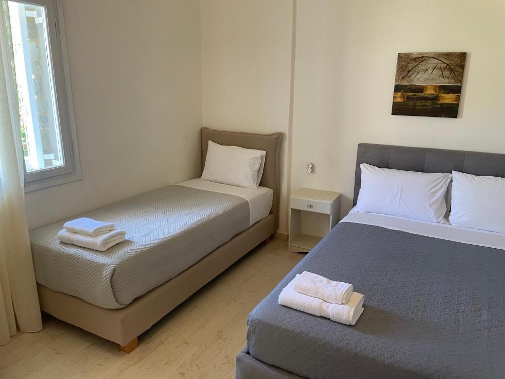 a small bedroom with two beds and a window at Villa Sylvia in Matala