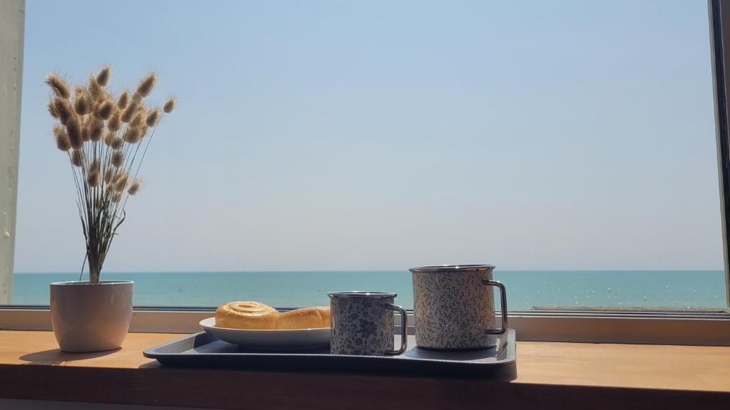 - un plateau avec une plaque de cuisson sur une table et une fenêtre dans l'établissement Oceandream vue sur l'ocean 6 personnes Nouveau !, à La Parée Preneau