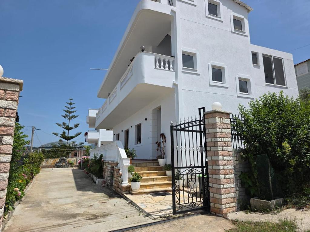 a white house with a gate in front of it at Maison de Fabjon in Ksamil