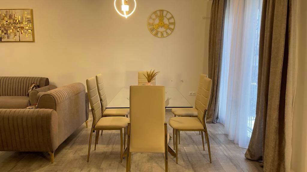 a dining room with a table and chairs and a couch at ZENHOME luxury appartement in Dilida