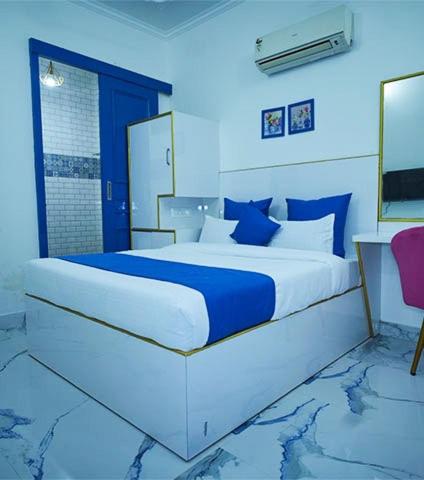 a blue bedroom with a large bed with blue pillows at The Host By Amaris in Amritsar