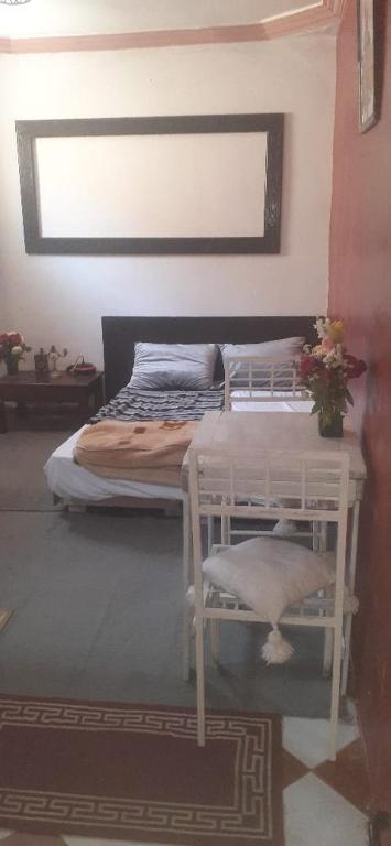 a bedroom with a bed with a flower vase on it at فرينة in Essaouira