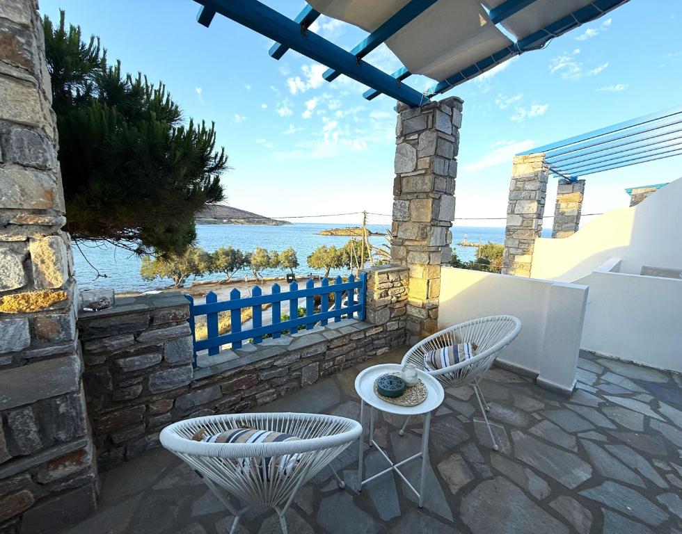 a patio with chairs and a table and a view of the water at Fabrika Apartments in Vári