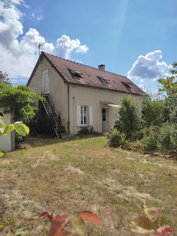 une petite maison blanche avec un escalier dans une cour dans l'établissement Gite des trois ormeaux, à La Celle-sous-Gouzon
