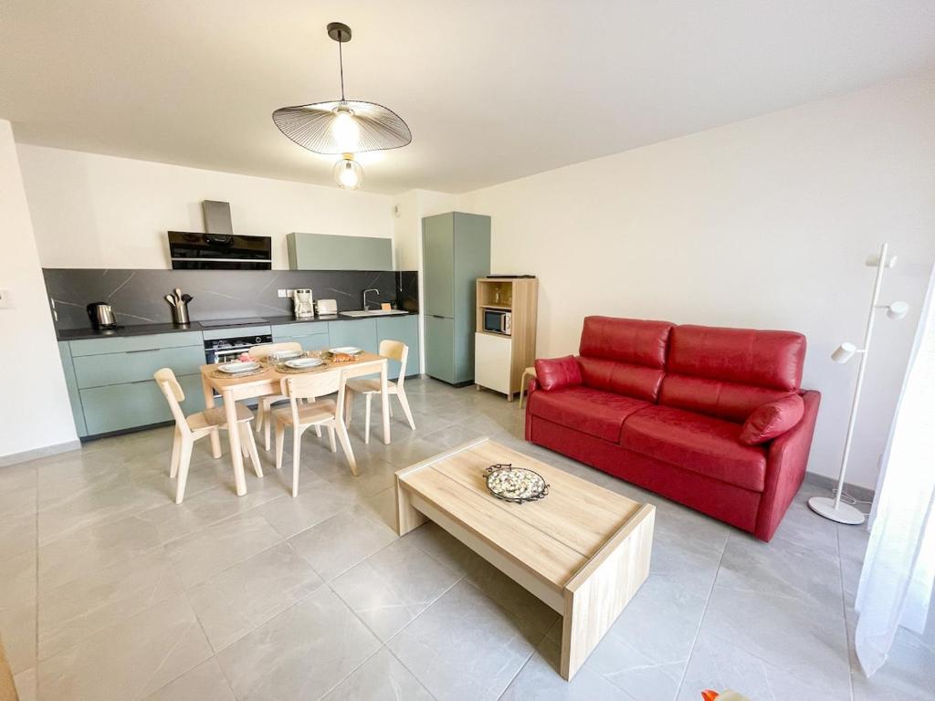 un salon avec un canapé rouge et une table dans l'établissement Joli T3 au coeur de Sanary avec garage, à Sanary-sur-Mer