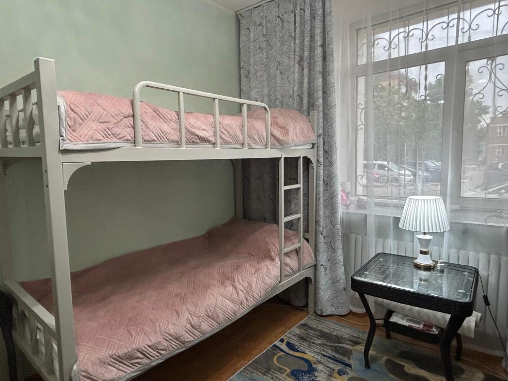 Un dormitorio con dos literas y una ventana. en Sunny Hostel Mongolia, en Ulán Bator