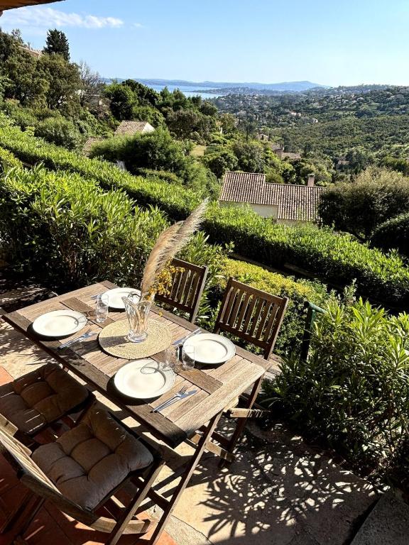 une table en bois avec des chaises et une fontaine à eau dans l'établissement Peaceful apartment with sea and hill view, air-conditioned, à Roquebrune-sur Argens