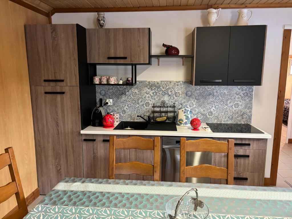 une cuisine avec des armoires noires et un comptoir dans l'établissement Le bureau, à Digoin