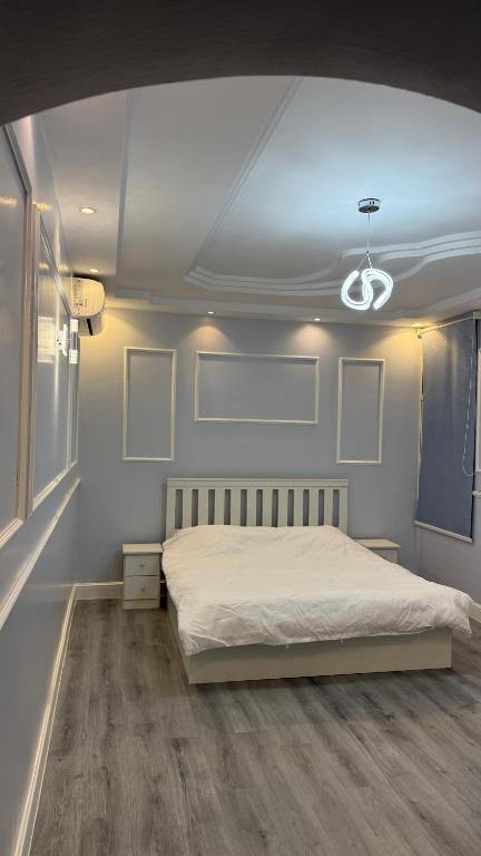 a bedroom with a white bed and a ceiling at غرفتين نوم ومجلس في ابها بالقرب من Lavanda Park in Abha