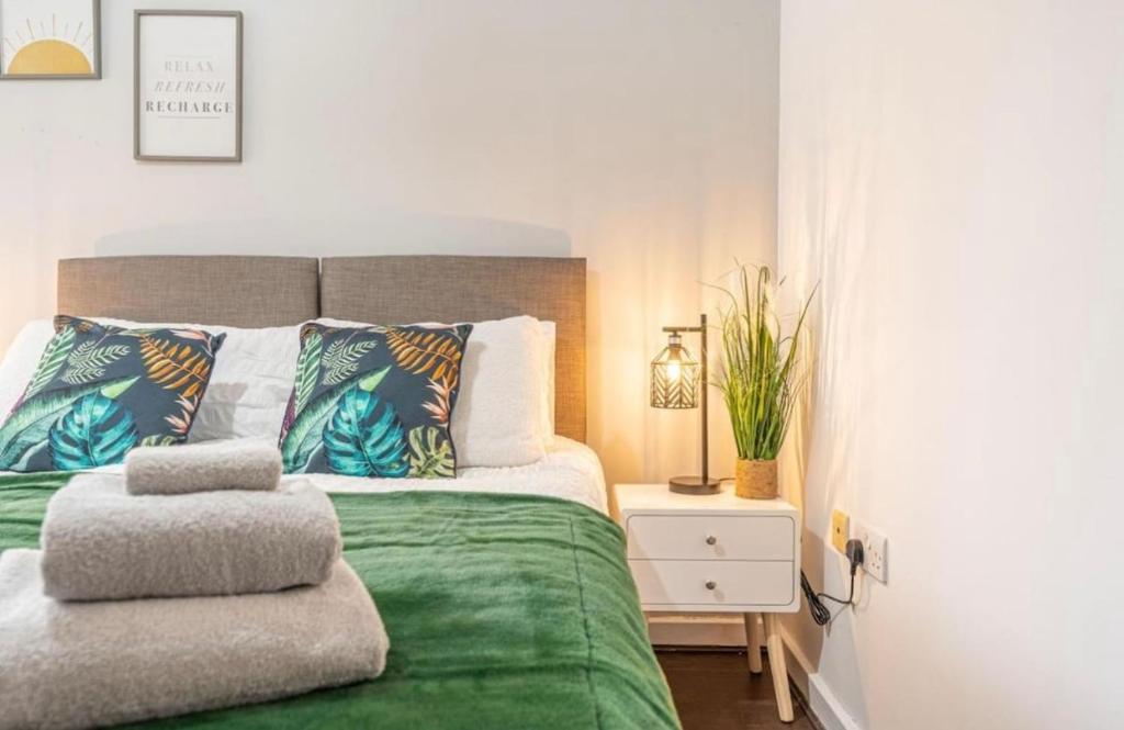 Un dormitorio con una cama verde con una planta encima. en 3Bedroom House Sleeps 6 Bradford, en Calverley